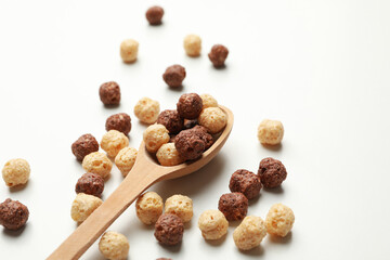 Spoon with corn balls on white background