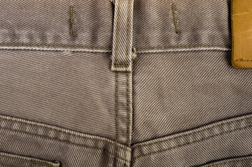 clothing items stonewashed cotton fabric texture with seams, clasps, buttons and rivets, macro