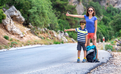 Obraz premium Woman with a child hitchhiking, The girl catches the car