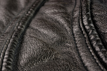 Old vintage genuine soft black leather texture background, top layer with pores and scratches, macro, close-up