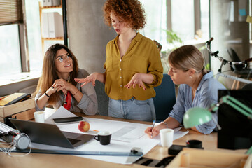 Businesswomen working on a new project. Colleagues discussing about problem they have to solved..