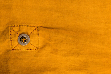 clothing items stonewashed cotton fabric texture with seams, clasps, buttons and rivets, macro