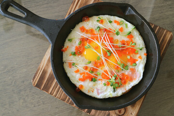 Top view of fried eggs topped with salmon roe, shrimp roe and microgreen for breakfast