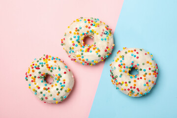 Tasty donuts on two tone background, top view