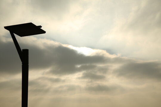 Wolkenformationen am Berliner Wannsee mit Laterne im Blickfeld