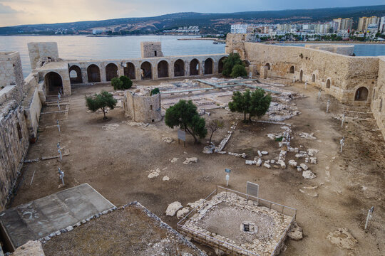 Panoramic view onto courtyard of medieval fortress Kizkalesi, Turkey. There are remains of towers, chapel,  barracks & rich house with mosaics. Modern city Kizkalesi & Mediterranean are on background
