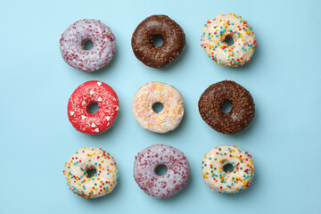 Flat lay with tasty donuts on blue background
