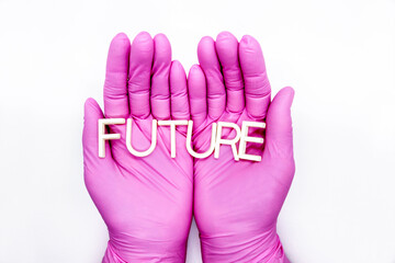 Human hands in medical gloves are holding word 'Future' made of letters
