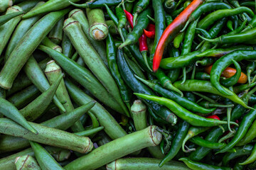 Green red pepper bunch closeup photo. Fresh spice pile on farm market table. Green and red chili pepper pod