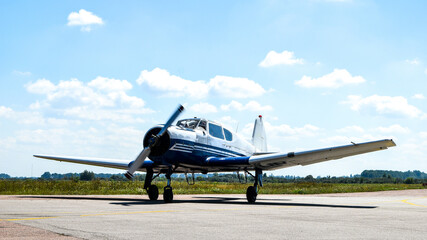 A small plane stands in the parking lot of an old airfield. Wings. Airport. Airfield. Flights by plane.