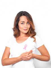 Woman in white t-shirt with pink ribbon supporting breast cancer awareness campaign