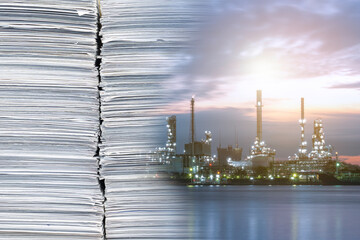 Double exposure of Oil refinery industry plant near the river with Stack of documents in office. Reduce paper to save energy concept.