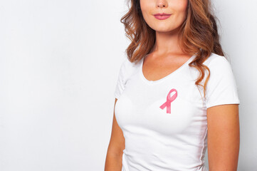 Woman in white t-shirt with pink ribbon supporting breast cancer awareness campaign