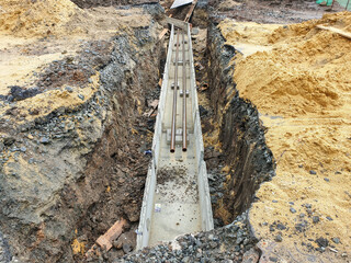 Laying of pipes of communications during the construction of a building. A dug trench into which...