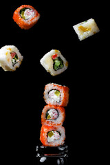 Sushi rolls assortment levitating against the black background