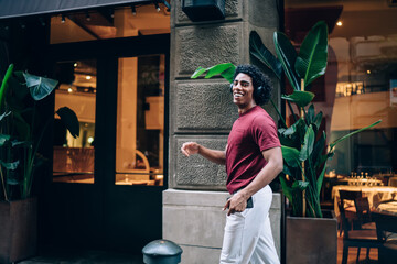 Happy man in headphones walking along street