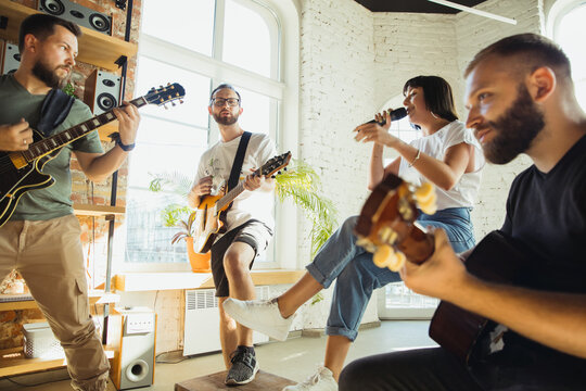 Inspiration. Musician band jamming together in art workplace with instruments. Caucasian men and women, musicians, playing and singing together. Concept of music, hobby, emotions, art occupation.
