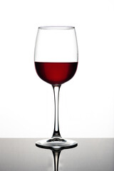 Wine glasses of different shapes with multi-colored drinks on a white background with reflection