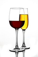 Wine glasses of different shapes with multi-colored drinks on a white background with reflection