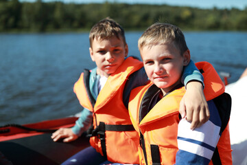 Fototapeta premium Two children in life jacket on boat