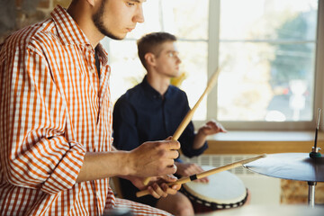Inspiration. Musician band jamming together in art workplace with instruments. Caucasian men and...