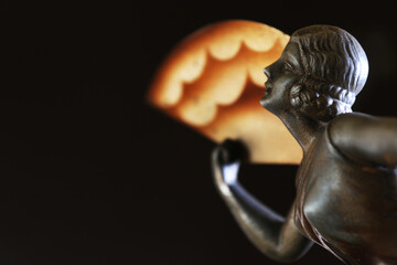 Ritratto di una giovane, elegante donna con ventaglio. Primo piano di scultura in metallo, tipico...