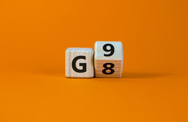 Symbol for the duration of the secondary school in Germany. Expanded wood cube with G8 '8 years' to G9 '9 years' or vice versa on beautiful orange background, copy space.  Educational concept. - obrazy, fototapety, plakaty
