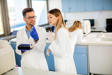 Group of young researchers analyzing chemical data in the laboratory