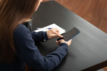 woman uses the phone touches the screen in a cafe lifestyle