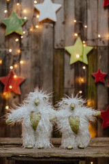 white sheep toys on the background of a Christmas decor of stars and garlands