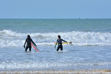 People practising sport in the waves on a beach in Brittany. France