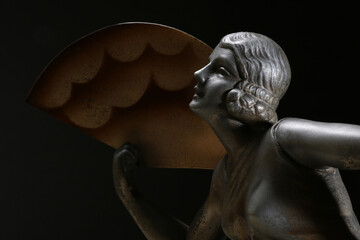 Ritratto di una giovane, elegante donna con ventaglio. Primo piano di scultura in metallo, tipico...