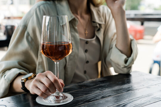 Woman sitting at a table enjoying a glass of rose wine