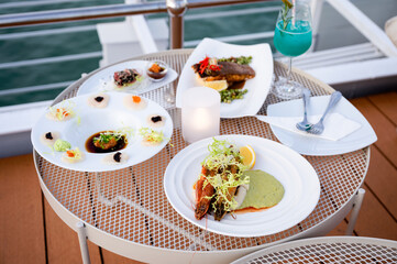 Various of seafood in white plate with blue cocktail on the table at patio of rooftop