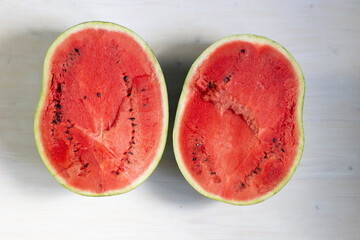 Halfs  of red watermelon on white wooden background