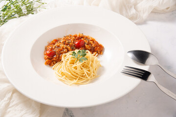meat pork spaghetti tomato sauce in white round dish with spoon fork decorate by white fabric stock photo