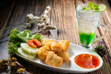 chicken nugget fry in ellipse dish fill with spicy sauce decorate by slice tomato cucumber and green soda topping mint dry flower on wood table texture stock photo morning light trapezoid flag text