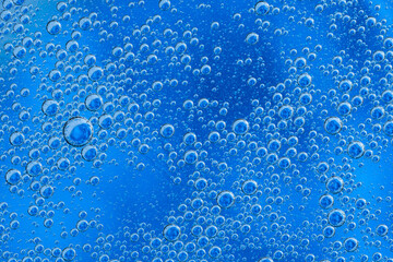 Large beautiful Oxygen bubbles underwater on a blue background macro.