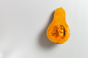 Sliced pumpkin with seeds and pulp on a white background. Copy space. Selective focus. Minimalism.