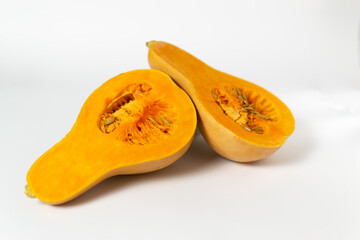 Sliced pumpkin with seeds and pulp on a white background. Copy space. Selective focus. Horizontal orientation. Minimalism.