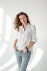 Young woman in white shirt on white background. Attractive girl in white clothes on a white background. Studio shot.