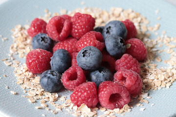 raspberries, blueberries and oatmeal on a plate