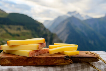 Cheese collection, French comte, beaufort or abondance cow milk cheese served outdoor with Alps...