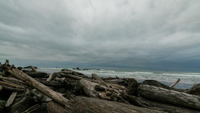  Timelapse tracking shot of moody sky over driftwood at Ruby Beach in Pacific Northwest in Washington State