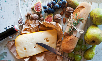 Fresh bread with tarragon on an old wooden background, top view. Gluten free mini baguette bread. Fruits, cheese and nuts, an appetizer for wine.