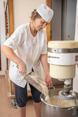 Baker woman adding flour