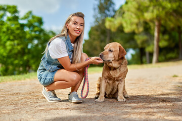 Portrait of a woman with a dog in the park.