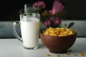 cornflakes in a plate and a glass of milk