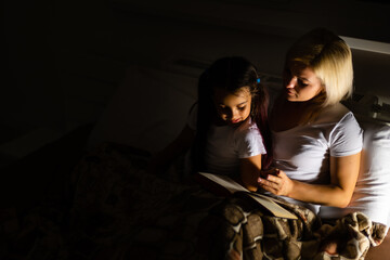 Mother And Daughter Learning To Read At Home