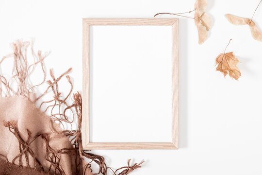 Autumn creative composition. Photo Frame, dry leaves, beige plaid on white background. Fall concept. Autumn background. Flat lay, top view, copy space